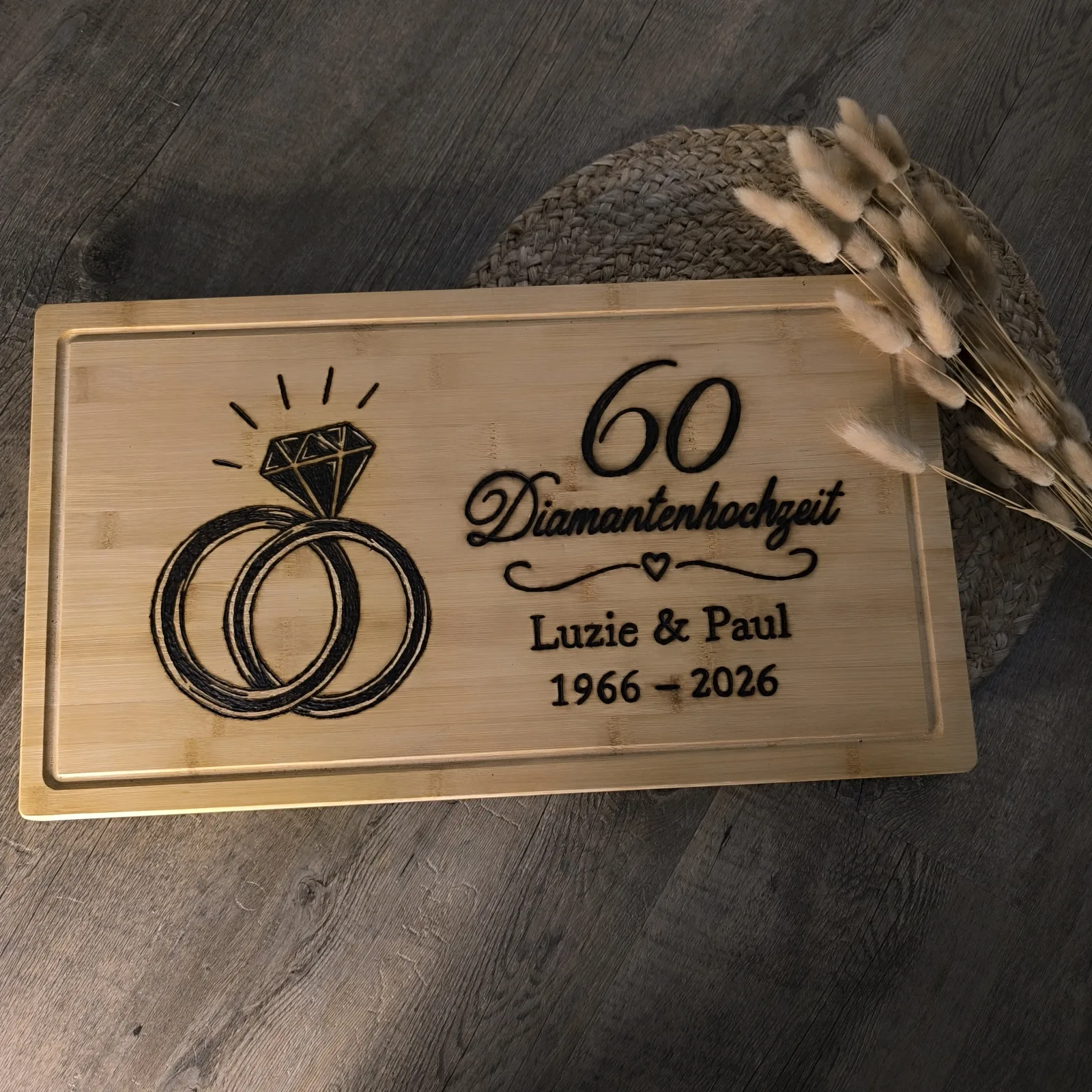 Bambusbrettchen zur Diamantenhochzeit mit Ringen, Diamant und der Aufschrift Luzie & Paul 1966 bis 2026.