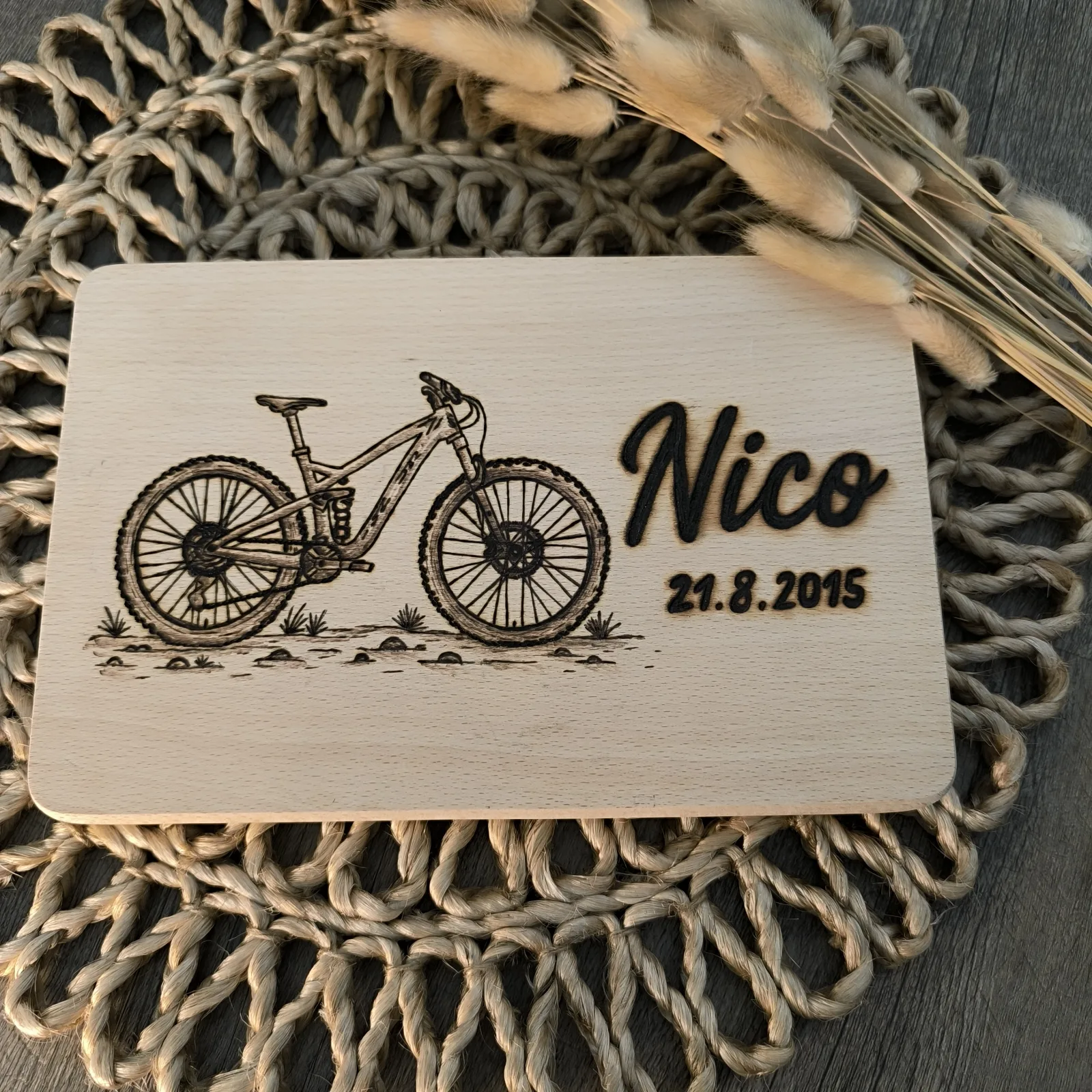 Buchenholzbrettchen mit detailreichem Mountainbike, dem Namen Nico und dem Datum 21.8.2015.