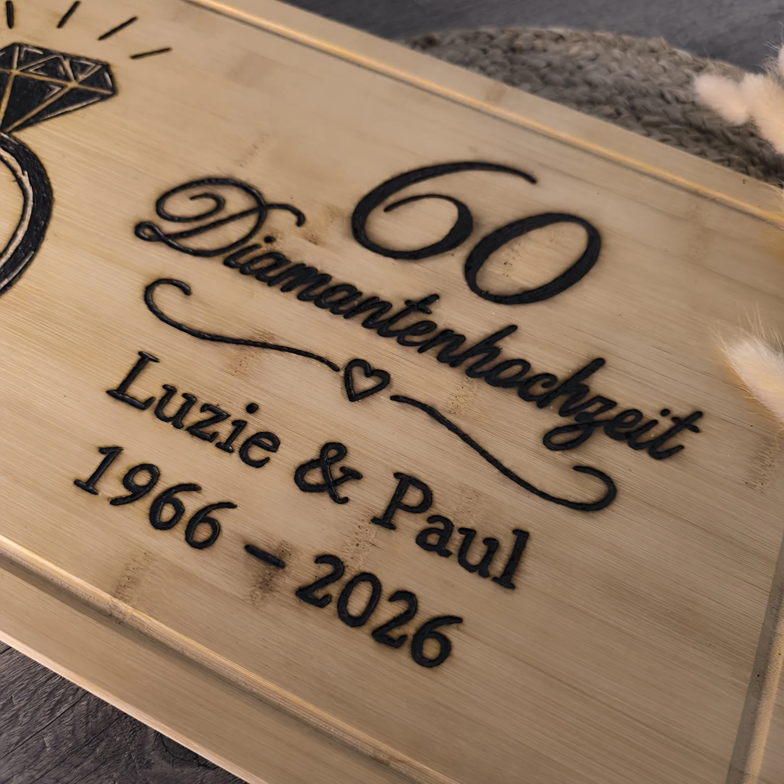 Detailansicht des Bambusbrettchens mit Aufschrift 60 Diamantenhochzeit, Luzie & Paul und 1966 bis 2026.