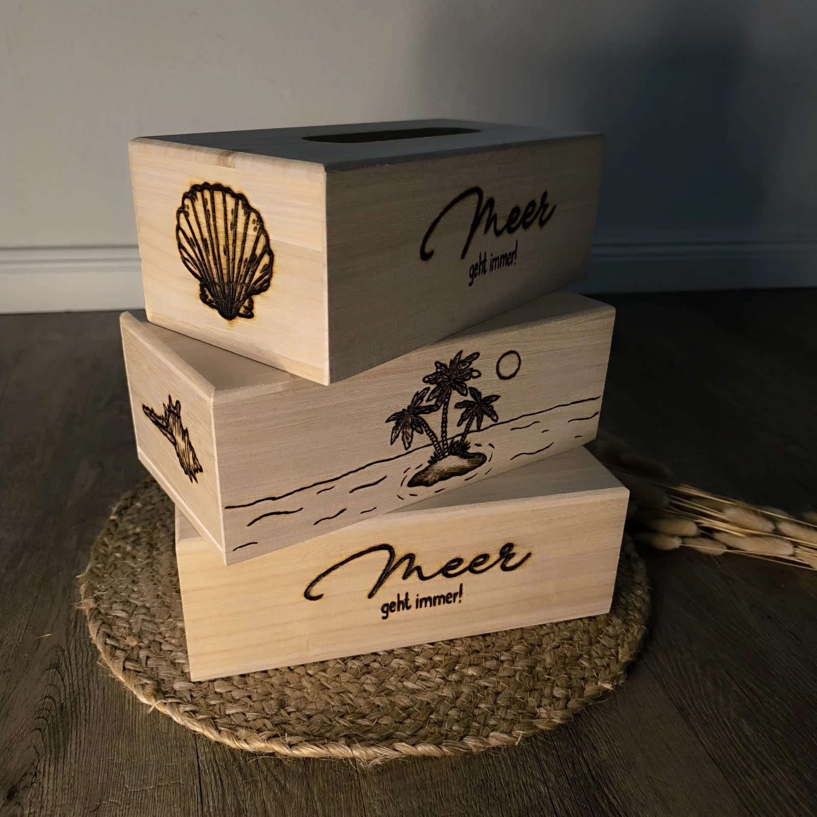 Gestapelte Holz Taschentücherboxen mit Muschel, Palme und Aufschrift Meer geht immer.