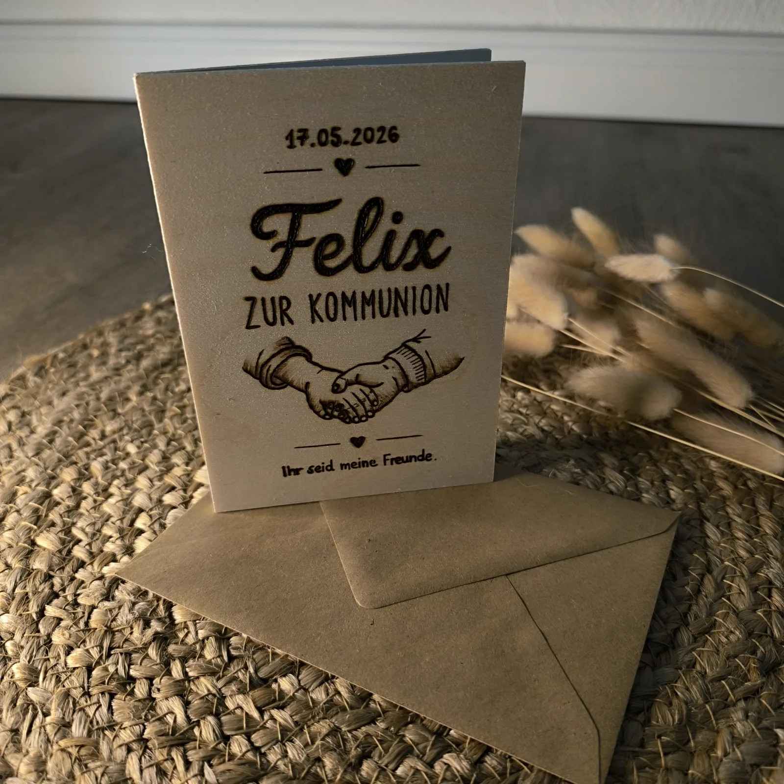 Holzkarte zur Kommunion mit Handschlagmotiv, dem Namen Felix und der Aufschrift Ihr seid meine Freunde.