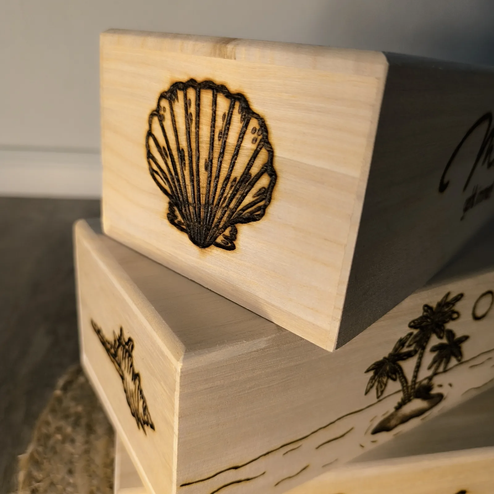 Nahaufnahme der Holzbox mit eingebrannter Muschel und maritimer Gravur.