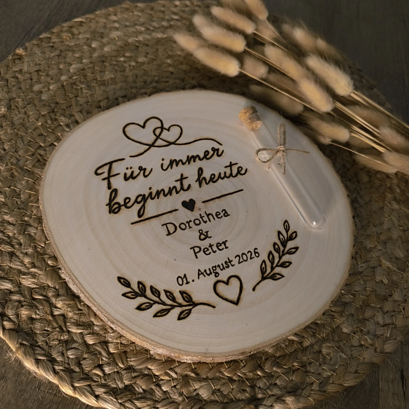 Personalisierte Holzscheibe mit Glasröhrchen, Herzen, Blättern und Hochzeitsaufschrift.