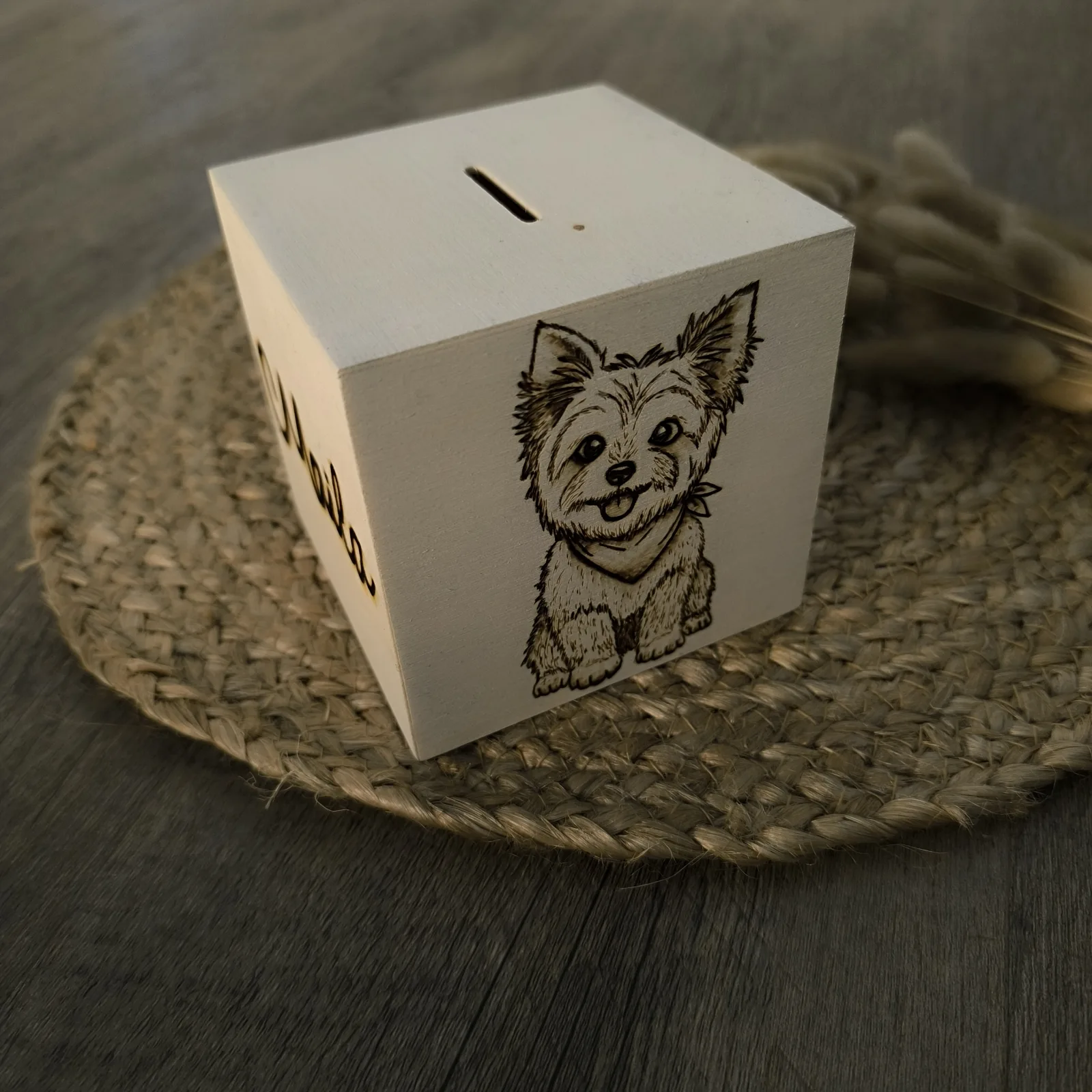 Weiße Holzspardose mit graviertem Hundemotiv und Münzschlitz auf Jutematte.