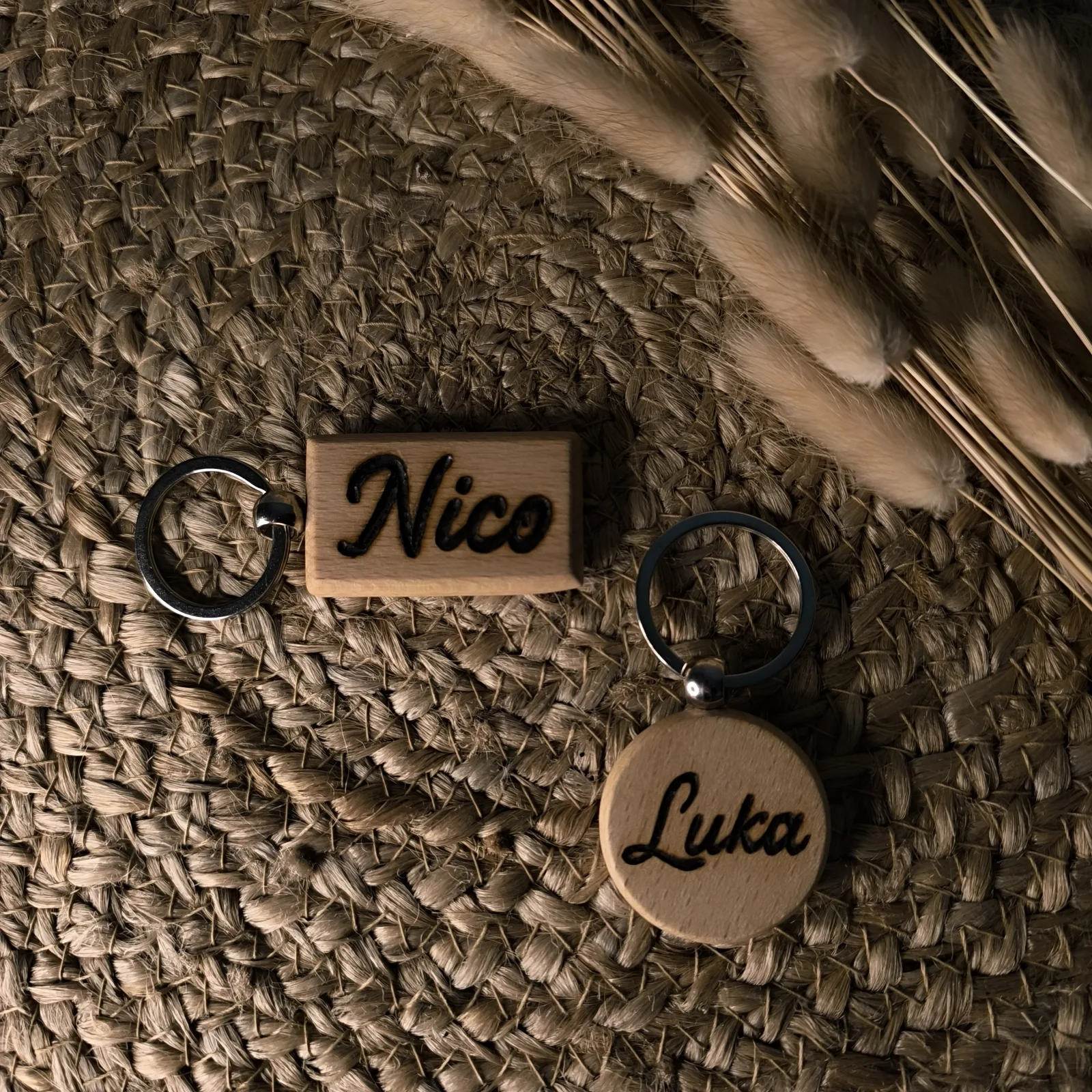 Zwei Holzschlüsselanhänger in runder und rechteckiger Form mit den eingebrannten Namen Nico und Luka.